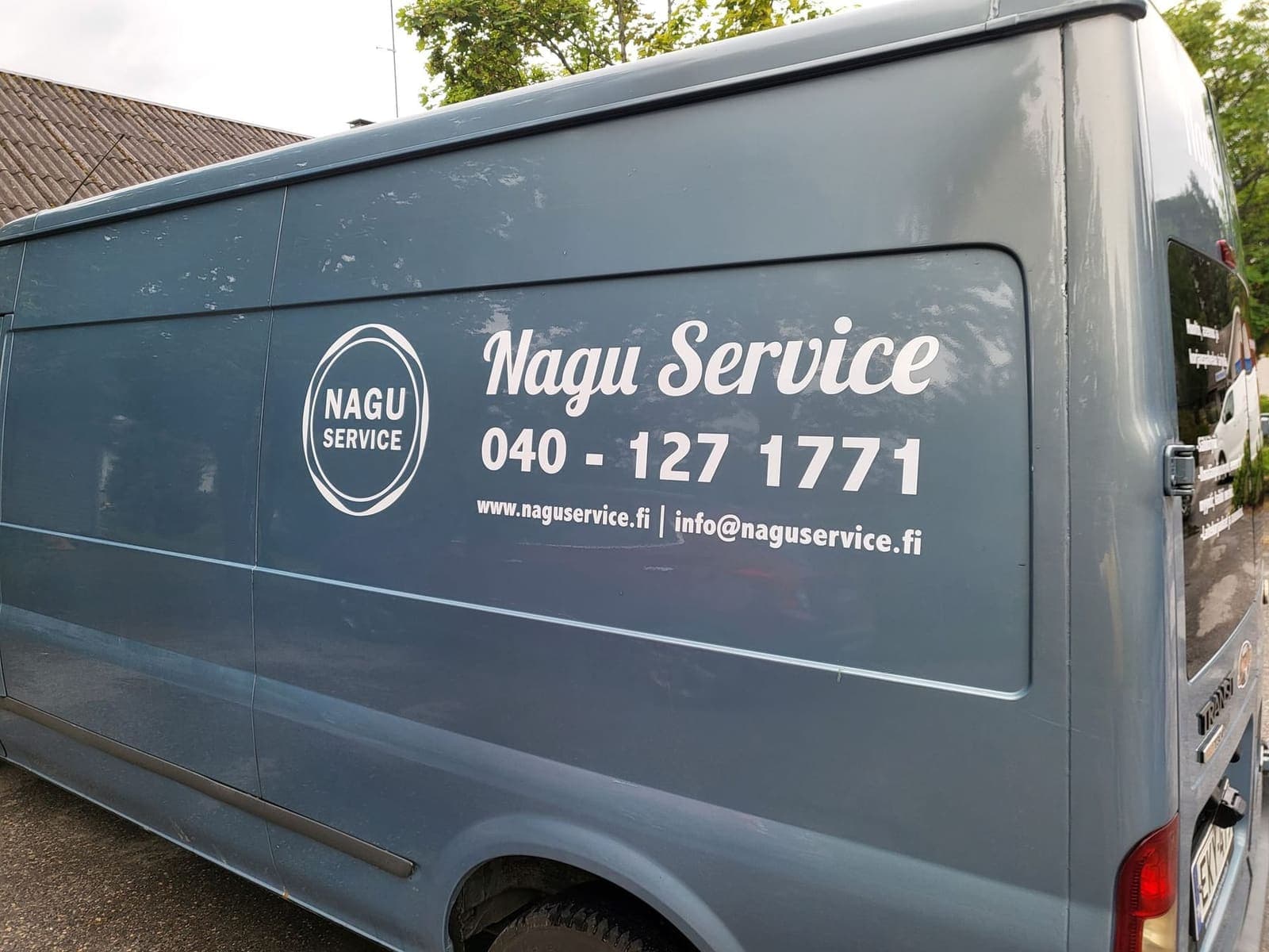 Vit Nagu Service-logotyp och kontaktuppgifter på en blågrå skåpbil