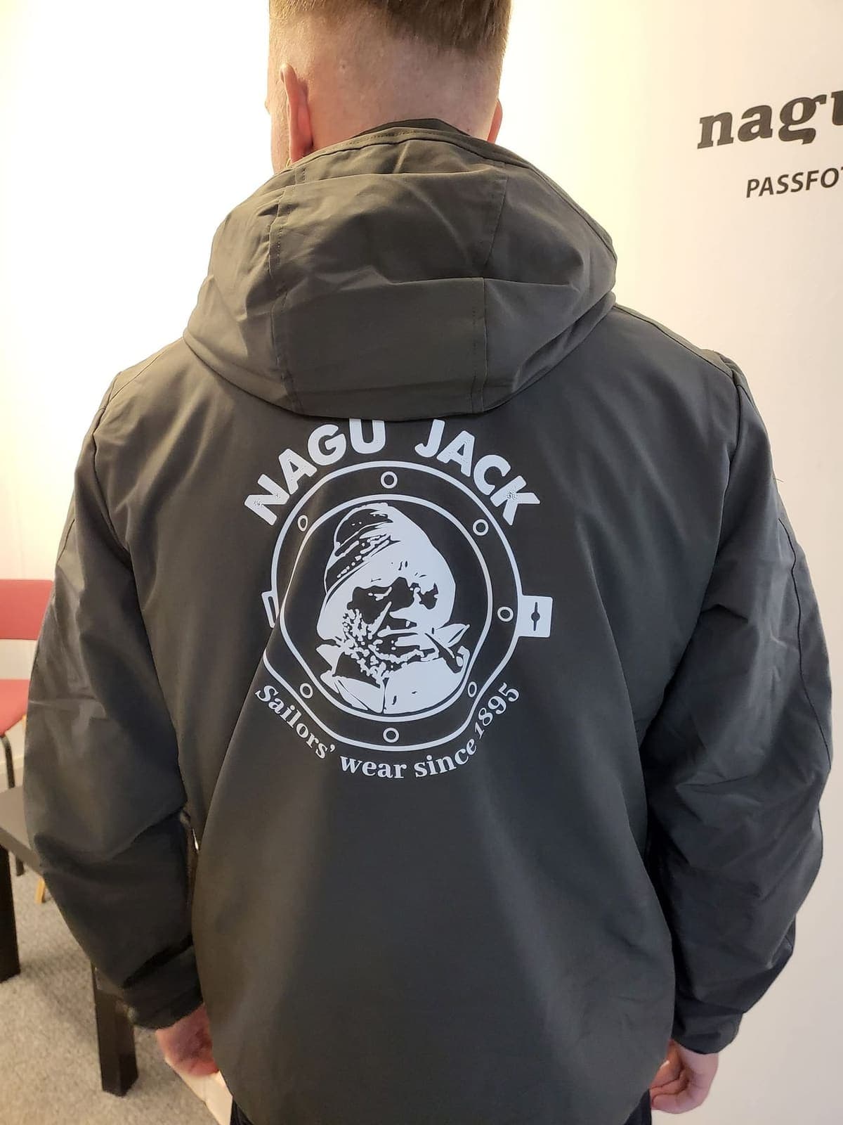 Mörk jacka med stort vitt Nagu Jack-tryck på ryggen