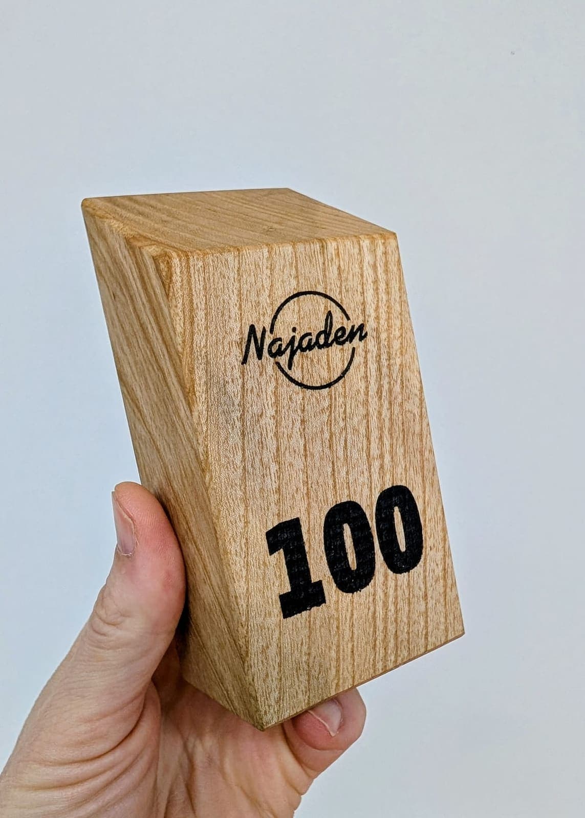 Bordsnummer 100 och logotyp lasergraverade i trä
