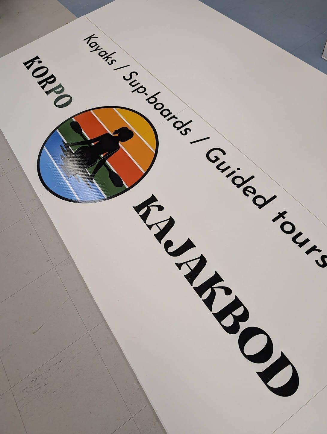 Vit Korpo Kajakbod-skylt med logotyp och text om kajaker och guidade turer