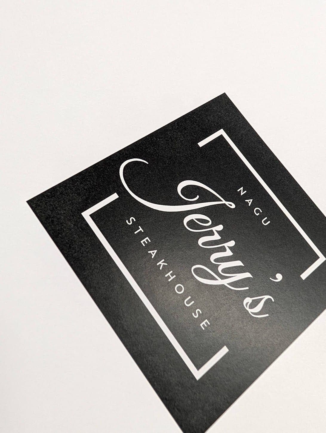 Svart visitkort för Jerry's Steakhouse med vit typografi
